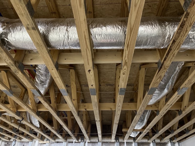 Insulated ductwork run through floor joists